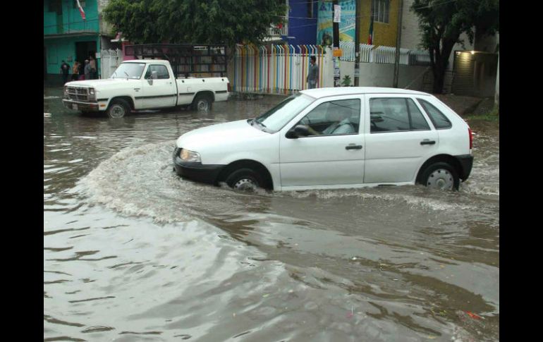 Un vehículo se abre paso por una calle inundada en Oaxaca. EFE /