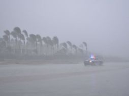 Un vehículo transita por una playa en medio de lluvia y fuertes vientos debido a la entrada de 'Odile' a Los Cabos. EFE  C. Robalo.  /