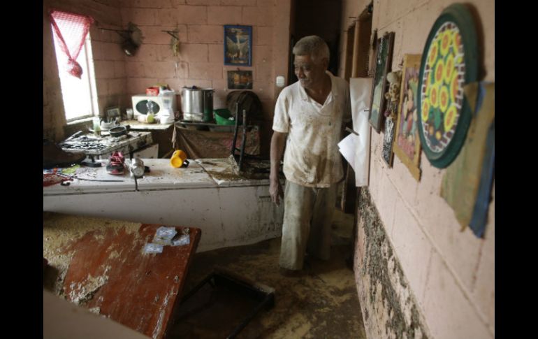 Enrique Cota Ceceña muestra los destrozos que el agua dejó en su casa, tras el paso de ''Odile''. AP V. Caivano  /