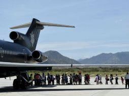 Decenas de turistas varados por el huracán 'Odile' abordan un avión de la Policía Federal para ser evacuados. AFP  R. Schemidt  /