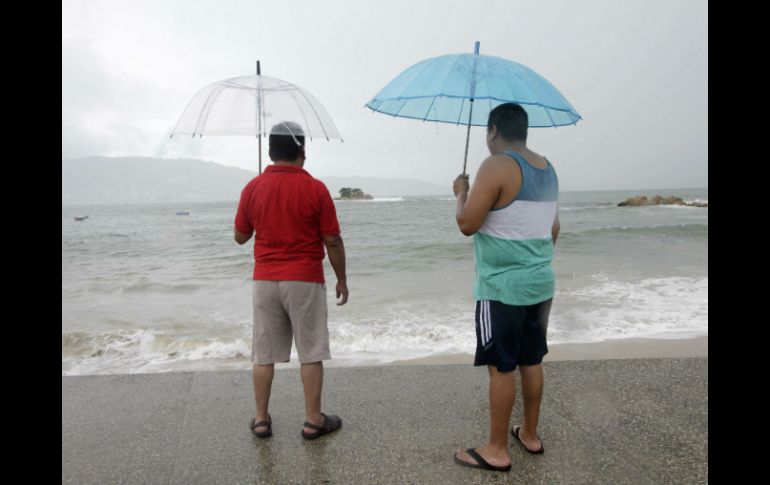 Dos personas observan, junto a una playa mexicana, el paso de ''Polo''. AFP P. Pardo  /