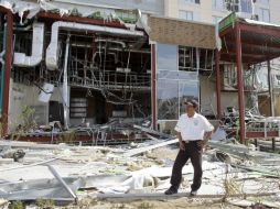 Un guardia de seguridad se para frente a un hotel destruido por el paso de 'Odile'. AP ARCHIVO /