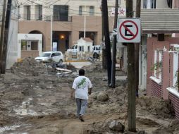 Con el Programa de Empleo Temporal el Gobierno pagará a quienes limpien las calles llenas de fango. AFP / A. Estrella