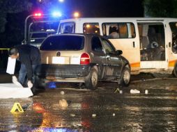 Peritos forenses investigan en la escena del crimen donde al menos dos personas fallecieron. EFE / L. Ocampo