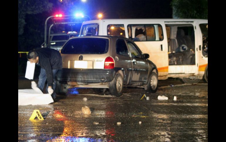 Peritos forenses investigan en la escena del crimen donde al menos dos personas fallecieron. EFE / L. Ocampo