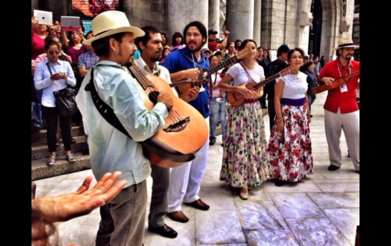 Personas que esperaban ingresar al concierto de la Orquesta Sinfónica Nacional, se detienen a admirar el 'performance'. TWITTER / @bellasartesinba