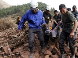 Equipos de rescate llevan un cuerpo entre las ruinas de la aldea de Misca, después del terremoto ocurrido la noche de ayer. AFP / ANDINA