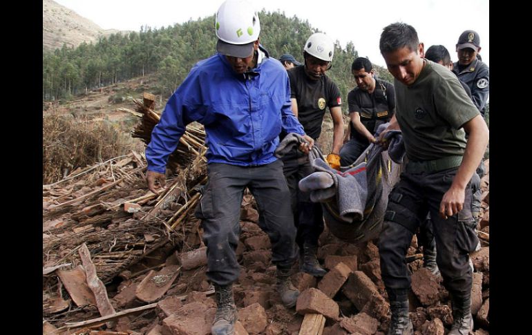 Equipos de rescate llevan un cuerpo entre las ruinas de la aldea de Misca, después del terremoto ocurrido la noche de ayer. AFP / ANDINA