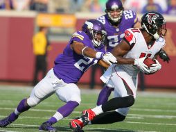 Julio Jones (11) de los Halcones lleva el balón mientras que Josh Robinson (21) de los Vikingos aplica presión tras de él. AFP /  A. Bettcher