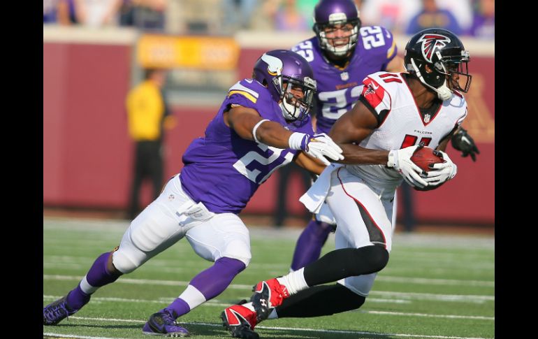 Julio Jones (11) de los Halcones lleva el balón mientras que Josh Robinson (21) de los Vikingos aplica presión tras de él. AFP /  A. Bettcher