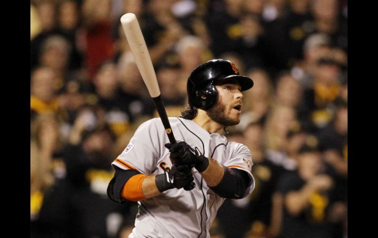 Brandon Crawford observa la bola que bateó en el cuarto rollo, que se convirtió en un cuadrangular con la casa llena. AFP / J. Aller