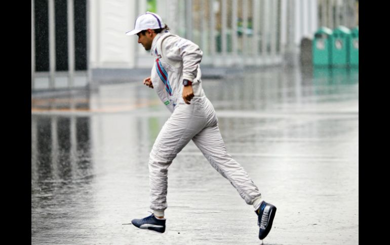 El piloto de Williams, Felipe Massa corre para escapar de la lluvia. EFE / S. Suki