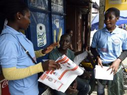 Los miembros de una asociación de Liberia que trabaja en la UNICEF hablan a la gente como parte de una campaña de sensibilización. AFP / P. Guyot