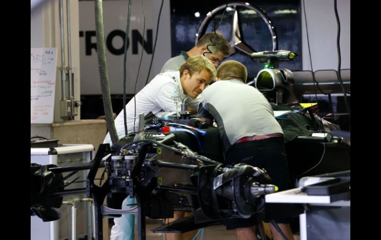 Nico Rosberg platica con uno de sus mecánicos en la puesta a punto del vehículo ubicado en el garage de Mercedes del circuito de Suzuka AP / S. Kambayashi