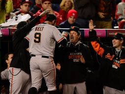 Brandon Belt es felicitado a la llegada a la caseta de los visitantes, luego de conectar su jonrón en la entrada 18. AFP / P. Smith