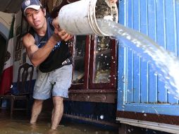 Un habitante de la colonia El Hoyo, de Ocotlán, saca agua de su casa tras la tormenta del fin de semana. EL INFORMADOR / M. Vargas