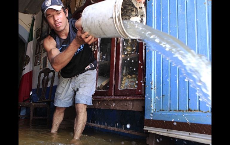 Un habitante de la colonia El Hoyo, de Ocotlán, saca agua de su casa tras la tormenta del fin de semana. EL INFORMADOR / M. Vargas