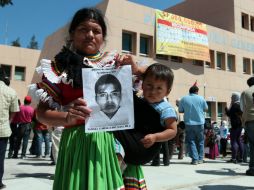 Una madre muestra la fotografía de su hijo, uno de los jóvenes desaparecidos durante la noche del 26 de septiembre. EFE / J. De la Cruz