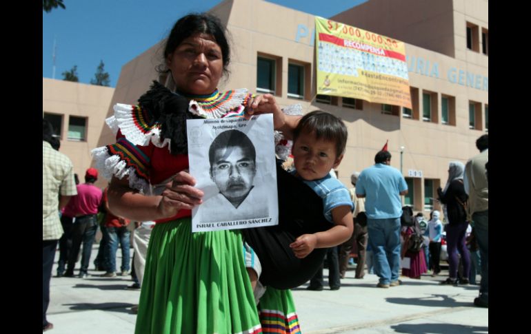 Una madre muestra la fotografía de su hijo, uno de los jóvenes desaparecidos durante la noche del 26 de septiembre. EFE / J. De la Cruz