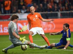 Arjen Robben dispara sobre la marca de un defensa y la salida del portero durante el partido. EFE / E.Dunand