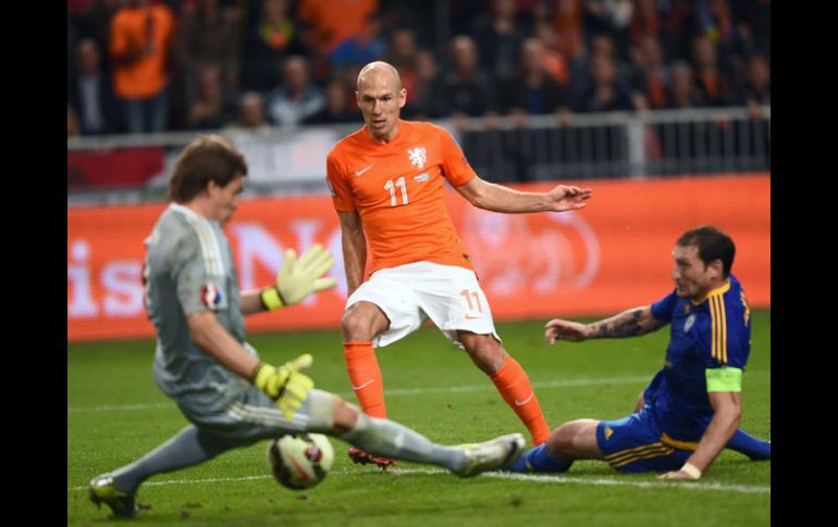 Arjen Robben dispara sobre la marca de un defensa y la salida del portero durante el partido. EFE / E.Dunand