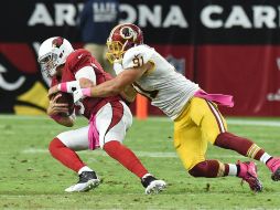 El mariscal de campo de los Cardenales, Carson Palmer es atacado por el apoyador de los Pieles Rojas,  Ryan Kerrigan. AFP / N. Hall