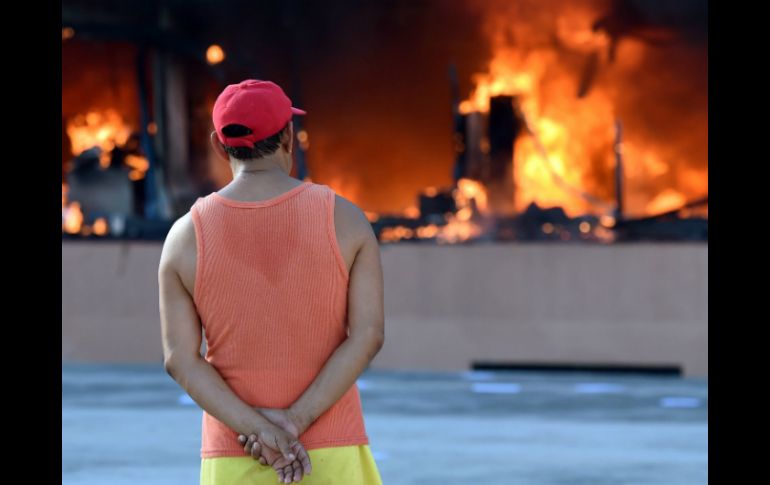 Un hombre observa el incendio provocado en el Palacio Municipal de Chilpancingo. AFP / Y. Cortez