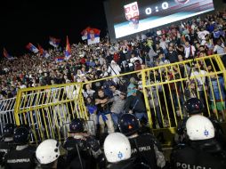 Algunos de los seguidores serbios saltan al césped para enfrentarse a los jugadores visitantes. AP / M. Drobnjakovic