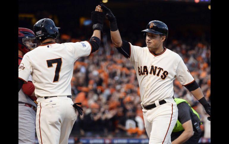 Joe Panik (d) de los Gigantes de San Francisco celebra con su compañero Gregor Blanco (i) tras anotar. EFE / J.Mabanblo