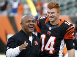 El coordinador ofensivo de los Bengalíes de Cincinnati bromea con el pasador Andy Dalton (14) previo al partido contra los Potros. AP / F. Victores