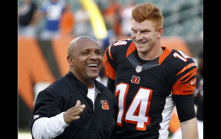 El coordinador ofensivo de los Bengalíes de Cincinnati bromea con el pasador Andy Dalton (14) previo al partido contra los Potros. AP / F. Victores