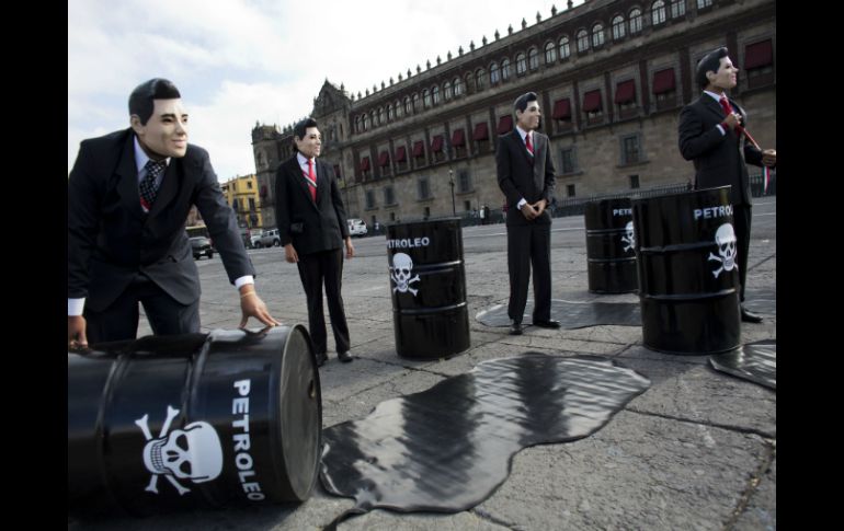 Con tambos vacíos y bolsas de plástico simulan tirar petróleo. AP / R. Blackwell