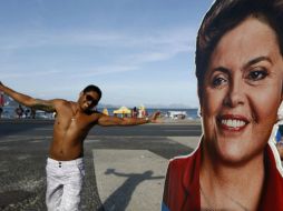 Un hombre posa tras un poster de la candidata a la reelección, en Río de Janeiro. EFE / M. Sayao