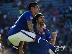 El argentino Mariano Pavone (d) celebra con su compañero Rogelio Chávez su anotación en contra del Morelia en el Estadio Azul. AFP / R. Schemidt