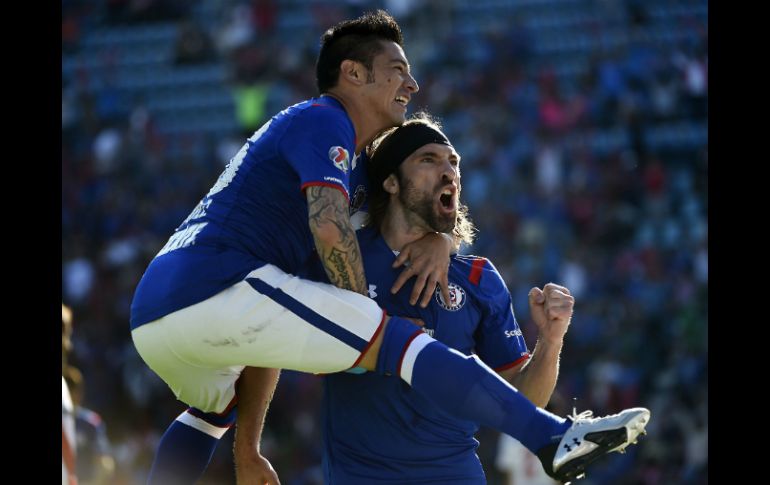 El argentino Mariano Pavone (d) celebra con su compañero Rogelio Chávez su anotación en contra del Morelia en el Estadio Azul. AFP / R. Schemidt