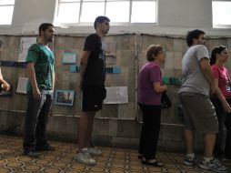 Uruguayos hacen fila en un colegio electoral en Montevideo para elegir al próximo presidente. AFP / G. Legaria