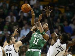 Evan Turner (c) de los Celtics disputa el balón con Mirza Teletovic (i) y Joe Johnson (d) de los Nets. EFE / CJ Gunther