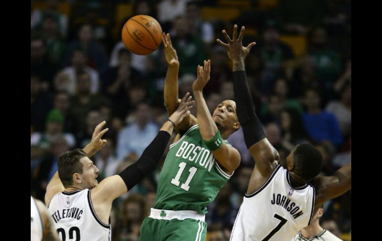 Evan Turner (c) de los Celtics disputa el balón con Mirza Teletovic (i) y Joe Johnson (d) de los Nets. EFE / CJ Gunther