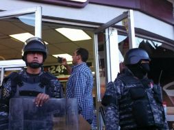 Antimotines resguardan la tienda de conveniencia que fue saqueada por ambulantes. EL INFORMADOR / A. García