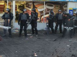 Antimotines resguardan la tienda de conveniencia que fue saqueada por ambulantes. ESPECIAL / Pablo Saenger