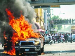 Una unidad de la PGR fue incendiada en plena Calzada Independencia por comerciantes informales inconformes con el operativo. EL INFORMADOR / F. Atilano