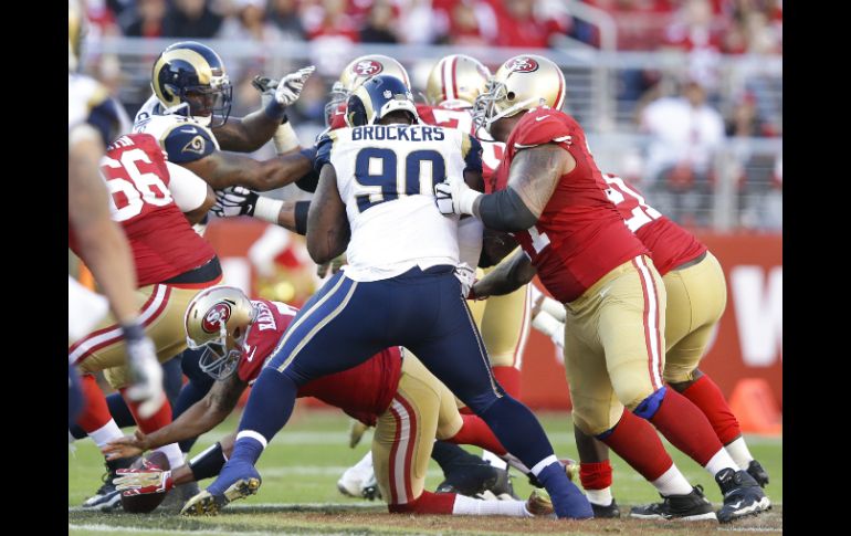 Colin Kaepernick (7) de los 49ers de San Francisco se zambulle para recuperar un fumble contra los Carneros de San Luis. AFP / E. Shaw