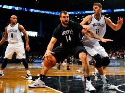 Nikola Pekovic (14) intenta duperar la marca de Brook López (11). El montenegrino aportó un doble-doble de 16 puntos. AFP / A. Goodlett