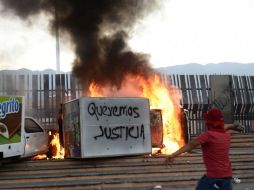 Simpatizantes de los normalistas prendieron fuego a varios vehículos a la entrada de Palacio de Gobierno de Guerrero, en Chilpancingo. AFP /  R. Schmidt