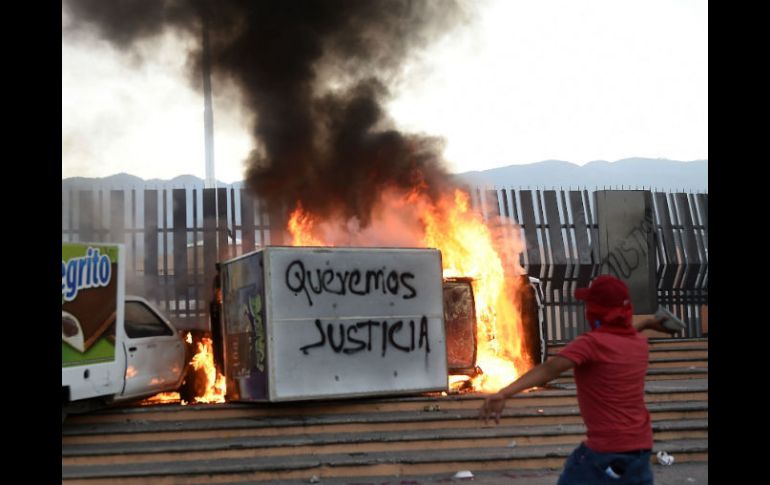 Simpatizantes de los normalistas prendieron fuego a varios vehículos a la entrada de Palacio de Gobierno de Guerrero, en Chilpancingo. AFP /  R. Schmidt