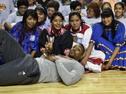 Dwight Howard, de los Rockets de Houston, posa con jóvenes tarahumaras invitadas al entrenamiento en la Arena Ciudad de México. AFP / Y. Cortez