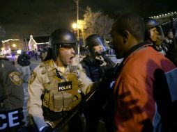 Los agentes se enfrentan a manifestantes después del anuncio del jurado de no procesar a policía. AP / D. Goldman