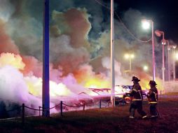 Decenas de negocios fueron saqueados y una docena más fueron incendiados, incluyendo varios vehículos de un lote de venta. AP / C. Gooden