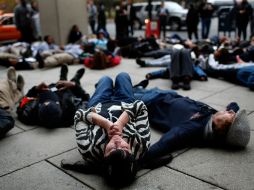 Acostados protestan afuera de una oficina policial, participan en la jornada de manifestaciones llamada '28 horas por Michael Brown'. AFP / W. McNamee