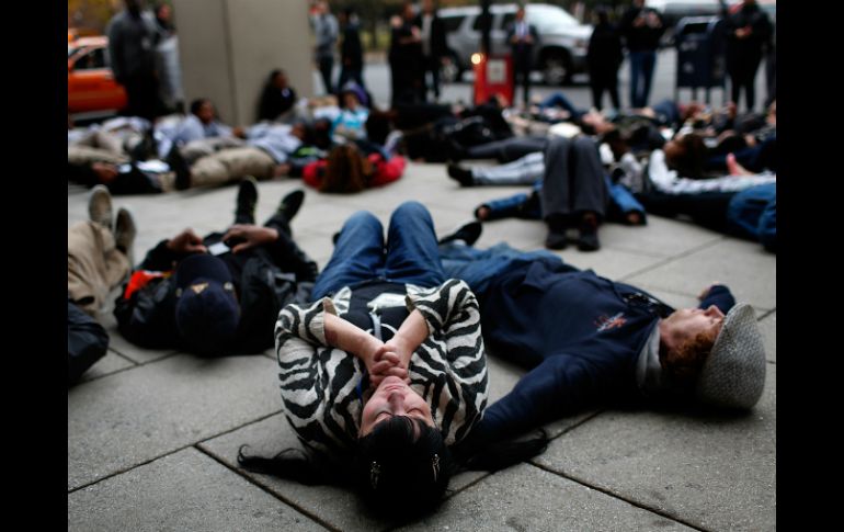 Acostados protestan afuera de una oficina policial, participan en la jornada de manifestaciones llamada '28 horas por Michael Brown'. AFP / W. McNamee